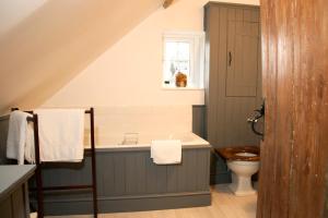 a bathroom with a toilet and a bath tub at The Cottage in Cross in Hand