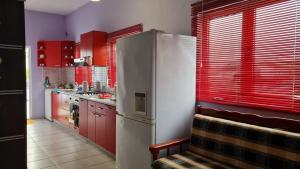 a kitchen with red cabinets and a refrigerator at Seven's Rooftop in Durrës
