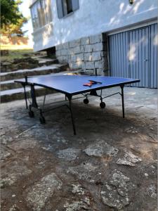 una mesa de ping pong sentada frente a un edificio en Casa Pepe, en Navarredonda de Gredos