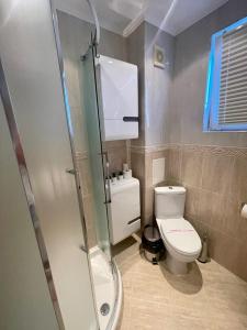 e bagno con servizi igienici e cabina doccia in vetro. di Byla Sun Day Apartament a Byala