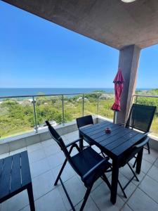 a table and chairs on a balcony with a view of the ocean at Byla Sun Day Apartament in Byala