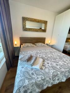 a bedroom with a bed and a mirror on the wall at Byla Sun Day Apartament in Byala