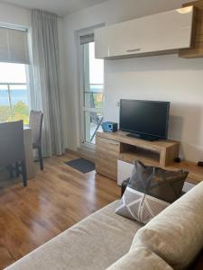 a living room with a couch and a flat screen tv at Byla Sun Day Apartament in Byala