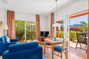 Vistamar في سانتا أورسولا: غرفة معيشة مع أريكة زرقاء وطاولة وكراسي