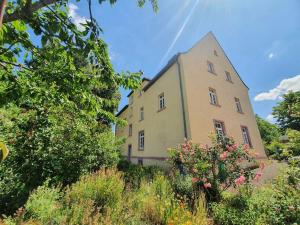 a large yellow building with a lot of plants at Helle Ferienwohnung - Südeifel in Ammeldingen