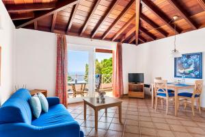 Una sala de estar con un sofá azul y una mesa. en Vistamar, en Santa Úrsula