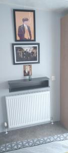 uma sala de estar com um radiador e duas fotografias na parede em Coghurst Hall themed static caravan em Westfield