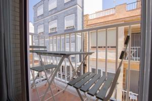 Una mesa y sillas en un balcón con ventana. en Apartamento en el Puerto de l’Ampolla, en L'Ampolla