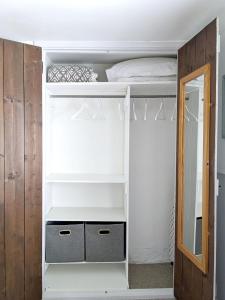 a bedroom with white bunk beds and a mirror at The Cottage in Cross in Hand