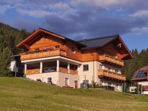a large house with a wooden roof on a hill at Haus Tauernseitn in Schladming