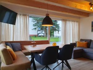 a living room with a couch and a table with chairs at Alpensuss in Kötschach