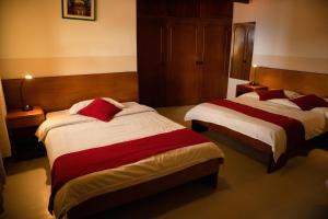 a room with two beds in a hotel room at Hotel Oberland in La Paz