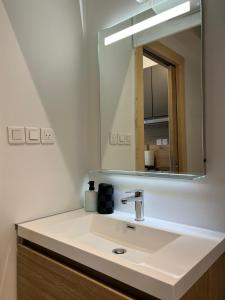 a bathroom with a sink and a mirror at L’esplanade du lac in Gérardmer