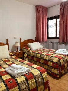Habitación de hotel con 2 camas y ventana en Casa Pepe, en Navarredonda de Gredos