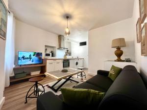 a living room with a couch and a table and a kitchen at Collioure, centre ville, joli T2 in Collioure