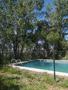 einen Zaun um einen Pool neben einem Baum in der Unterkunft Quintinha a 35min de Lisboa in Mafra