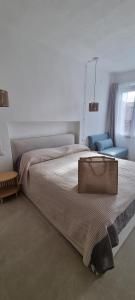 a bedroom with a large bed and a chair at Casa Brì Boutique Rooms in Santa Teresa Gallura