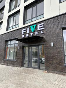 a large brick building with a sign on it at Five Hotel in Astana