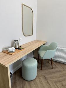 a desk with a mirror and a chair and a stool at Five Hotel in Astana