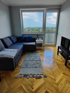 ソポトにあるApartament Morski Sopotのリビングルーム(青いソファ、大きな窓付)