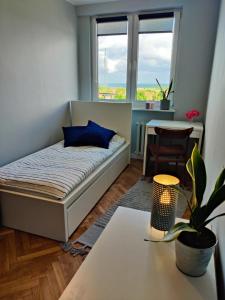 ソポトにあるApartament Morski Sopotのベッドとテーブル付きの小さな部屋