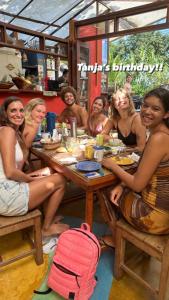 伊塔卡雷的住宿－Mais Que Nada Itacaré - Hostel, Bar & Breakfast，坐在桌子上的一群妇女
