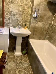 ein Badezimmer mit einem Waschbecken und einer Badewanne neben einem Waschbecken in der Unterkunft Apartament Raszyn za grosze 