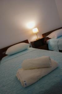 FrátsiaにあるGreen Parrot Apartmentsのベッド1台(タオル2枚付)
