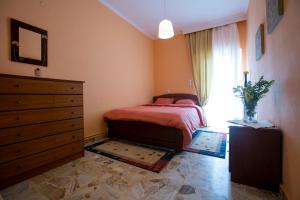 ein Schlafzimmer mit einem Bett, einer Kommode und einem Fenster in der Unterkunft ELATALIA Plastira Lake 