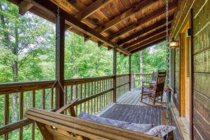 a porch of a cabin with a swing at Pooh Bear, Hot Tub, WIFI, 685 FREE tickets each paid day!!! in Sevierville