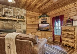 a living room with a couch and a television in a cabin at Pooh Bear, Hot Tub, WIFI, 685 FREE tickets each paid day!!! in Sevierville