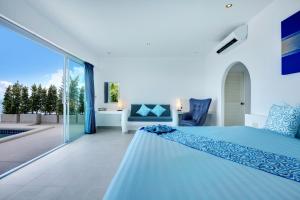 a bedroom with a blue bed and a balcony at La Perle Resort Koh Samui in Mae Nam