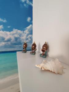 un groupe de figurines assises sur un mur blanc sur la plage dans l'établissement Casa Airen con jacuzzi, à Miguel Esteban