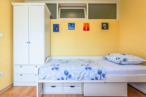 una camera con un letto bianco e una parete gialla di Apartment Yellow Duck - CITY CENTER a Makarska
