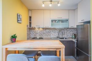 una cucina con tavolo in legno e frigorifero di Apartment Yellow Duck - CITY CENTER a Makarska