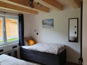 1 dormitorio con 2 camas y ventana en Alpensuss, en Kötschach-Mauthen