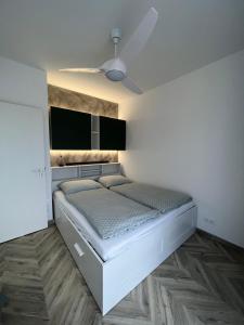 een slaapkamer met een bed en een plafond bij Beige Villa Balatonkenese in Balatonkenese