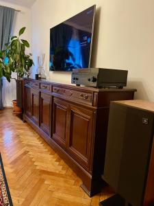 a large flat screen tv on top of a wooden entertainment center at Dream Home in Turda