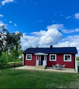 a red house with a table in front of it at Litet hus på landet 
