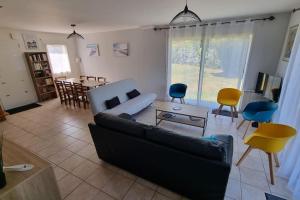 a living room with a couch and a table and chairs at Maison de famille située à Saint-Molf. in Saint-Molf