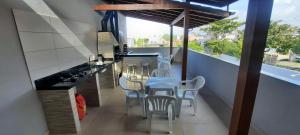 a kitchen with a table and chairs on a balcony at Apartamento Pinheira in Palhoça