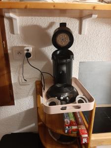 uma máquina de café sentada em cima de uma prateleira em Studio FLOCON 18m2 en RDC em Les Carroz d'Arâches