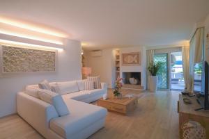 a living room with a white couch and a television at Summer Luxury Apartment Adults Only in Olbia