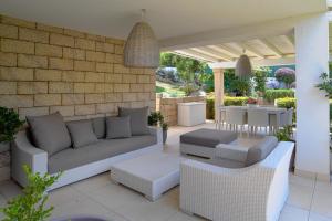 a patio with a couch and chairs and a table at Villa Summer Luxury Apartment in Olbia