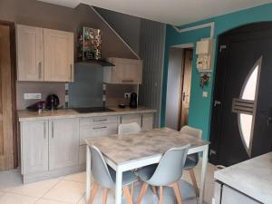 a kitchen with a table and chairs in it at Au chant des mandarins 2 gites de 15 personnes et un 3ème gite à proximité de 12 in Charmes +21 photos