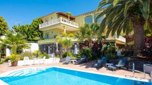 a villa with a swimming pool in front of a house at Vistamar in Santa Úrsula