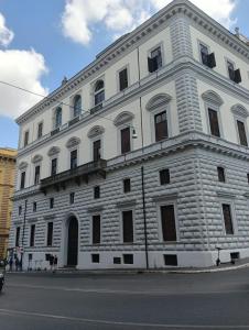 un gran edificio de ladrillo blanco en el lateral de una calle en Novembre 152 Apartment en Roma