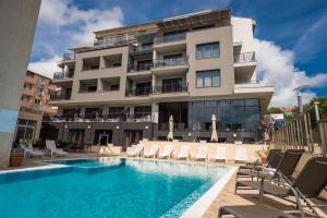 a hotel with a swimming pool in front of a building at Polina Beach in Sozopol