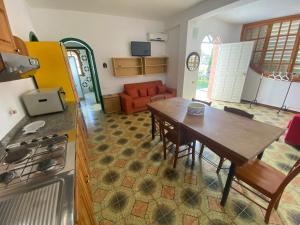 una cucina e un soggiorno con tavolo e divano di DesyMar Inn a Fontane Bianche