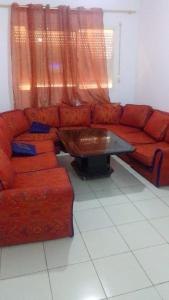 a living room with a red couch and a coffee table at Appartement Fès in Fez